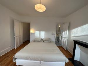a bedroom with a large white bed in a room at Villa Jean- plein centre Etretat in Étretat