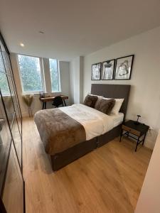 a bedroom with a large bed and a desk at Stylish 1 Bedroom Apartment in Purley, Croydon in London