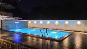 a swimming pool at night with lights on a wall at Kamal Homes in Kīhīm