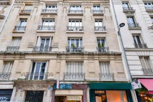 ein hohes Gebäude mit Fenstern und Balkonen in der Unterkunft Bel appartement pour 4 personnes in Paris