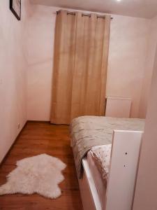 a bedroom with a bed with a curtain and a rug at Apartament Hubertus in Bochnia