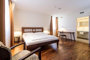 1 dormitorio con 1 cama, mesa y sillas en Hotel Schweizerhof Basel, en Basilea