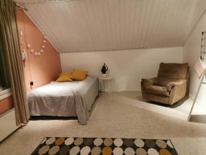 1 dormitorio con 1 cama y 1 silla en Arctic Lakeside Home, en Kemijärvi