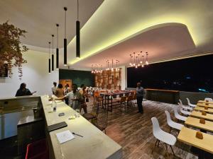 a restaurant with white tables and chairs and people at Burundi Palace Boutique Hotel in Bujumbura
