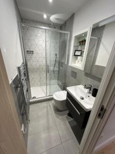 a bathroom with a shower and a toilet and a sink at Stylish 1 Bedroom Apartment in Purley, Croydon in London