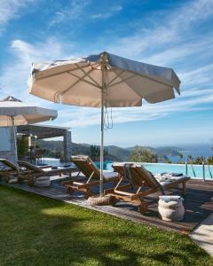 a patio with chairs and an umbrella and a pool at Luxury Villa in Kechria 2 in Kechria