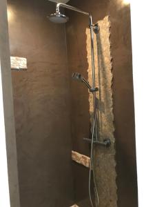 y baño con ducha y pared de piedra. en Appartement PALAZZI 1, en LʼÎle-Rousse