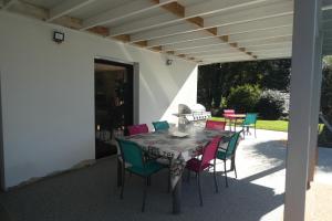 einen Tisch und Stühle auf einer Terrasse in der Unterkunft Chez Valérie in Merlevenez