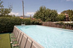a swimming pool with chairs next to a fence at Casa Tiziana con ampio patio e parcheggio riservato in Albenga