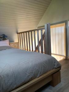 a bedroom with a bed and a wooden railing at Le Domaine de la Claire Fontaine gites & chambres d'hôtes avec spas privatifs in Montvalent