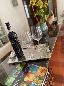 einen Tisch mit zwei Gläsern und einer Flasche Wein in der Unterkunft Casa em São Roque Roteiro do Vinho in São Roque