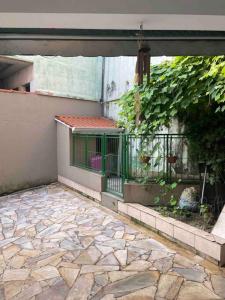 a building with a gate and a stone patio at Casa em São Roque Roteiro do Vinho in São Roque