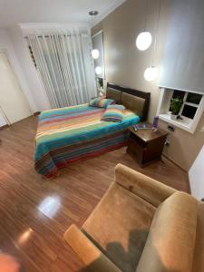 ein Wohnzimmer mit einem Bett und einem Sofa in der Unterkunft Casa em São Roque Roteiro do Vinho in São Roque