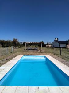 a large blue swimming pool with a gazebo at Entre fincas alojamiento rural in San Rafael