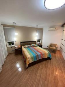 a bedroom with a bed and a chair in it at Casa em São Roque Roteiro do Vinho in São Roque
