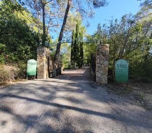 ein Tor am Eingang zu einem Park mit einem Schild in der Unterkunft Domaine des Oliviers in Draguignan