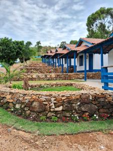 eine Reihe von Häusern mit einer Steinmauer in der Unterkunft Pousada Fazendinha Alto da Serra in Serra Negra