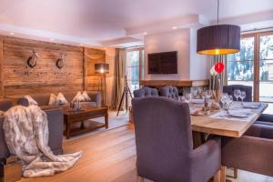 a dining room and living room with a table and chairs at Circle Chalets Arlberg in Zug