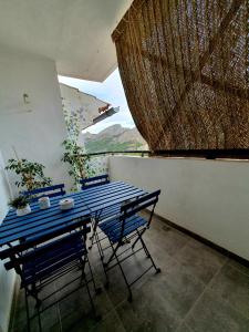 einen blauen Tisch und Stühle auf einem Balkon mit Aussicht in der Unterkunft EL ÚNICO apartment with jacuzzi and art in Guadalest