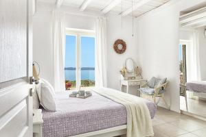 a white bedroom with a bed and a window at Luxury Villa in Kechria 2 in Kechria