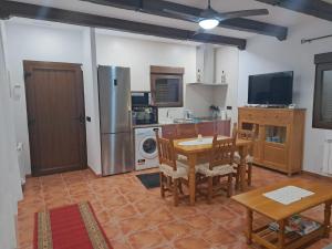eine Küche mit einem Tisch und eine Küche mit einem Kühlschrank in der Unterkunft Casa Rural La Veguilla in Argés