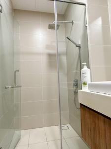 een douche met een glazen deur in de badkamer bij Green Haven 1 Bedroom in Masai
