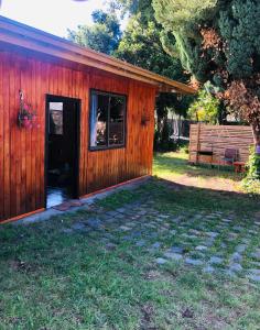 un edificio de madera con una puerta y un banco en Casa Alma, en Pucón