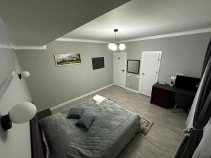 a bedroom with a bed and a table in it at Pensiunea GRS Tunari in Tunari