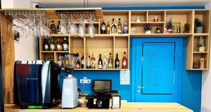 a bar with a blue door and bottles of alcohol at Pensiunea GRS Tunari in Tunari