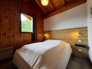 a bedroom with a bed in a wooden cabin at Appartement Lanslevillard, 3 pièces, 4 personnes - FR-1-508-296 in Lanslebourg-Mont-Cenis