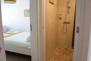 a bathroom with a shower next to a bed at Casa da fonte de baixo in Barcelos