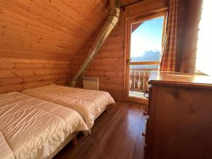 a bedroom with two beds and a large window at Chalet La Joue du Loup, 4 pièces, 8 personnes - FR-1-651-11 in Le Dévoluy