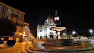 a fountain in front of a building at night at Casa da fonte de baixo in Barcelos +16 photos
