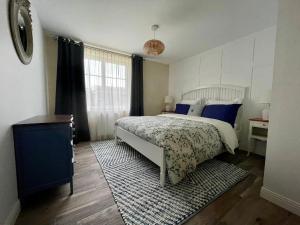 a bedroom with a bed with blue pillows and a rug at Les Cottages du Manoir, Jacuzzi -Crozon in Crozon +20 photos