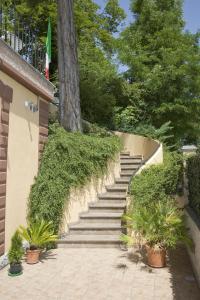 um conjunto de escadas com plantas ao lado de uma árvore em Raffaello Residence em Sassoferrato