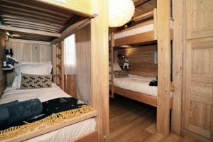 two bunk beds in a room with wooden walls at Chalet Ar Menez in Les Deux Alpes