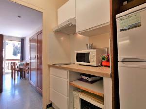y cocina con encimera, microondas y nevera. en Appartement Le Dévoluy, 1 pièce, 4 personnes - FR-1-525-278 en Le Dévoluy
