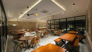 a restaurant with wooden tables and chairs and windows at Inika in Ponnampet