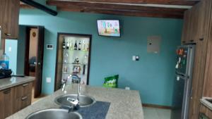 cocina con fregadero y pared azul en Virgi Hostel, en Quito