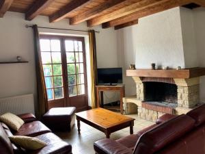 ein Wohnzimmer mit einem Sofa und einem Kamin in der Unterkunft Maison familiale avec grand jardin arboré in Trélissac