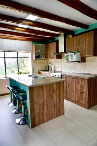 uma grande cozinha com armários de madeira e uma bancada em Virgi Hostel em Quito