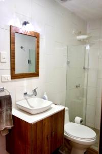 uma casa de banho com um lavatório, um WC e um espelho. em Virgi Hostel em Quito