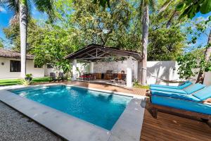 uma piscina num quintal com um sofá azul em Hacienda del Mar em Tamarindo