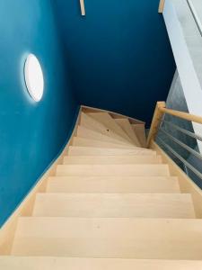 a staircase in a room with a blue wall at Peaceful House & Garden (20min EU & City Center) in Brussels
