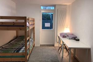Cette chambre dispose de lits superposés, d'un bureau et d'une fenêtre. dans l'établissement Peaceful House & Garden (20min EU & City Center), à Bruxelles