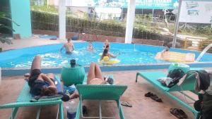 a group of people laying in a swimming pool at Ha Giang Lotus Hostel Motorbikes and Tours in Ha Giang