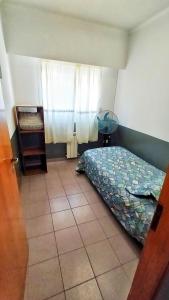 um pequeno quarto com uma cama e uma janela em Centro II em Venado Tuerto