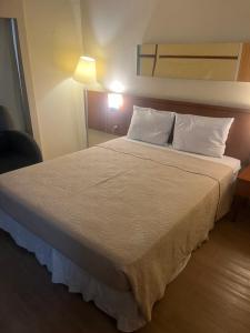 sypialnia z łóżkiem z białą pościelą i poduszkami w obiekcie Flat Vila Mariana Borges Lagoa com garagem 804 w São Paulo