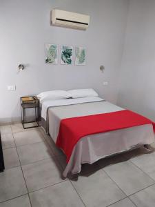 Un dormitorio con una cama con una manta roja. en Lantonia en Oncativo