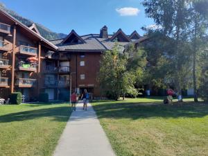 personnes marchant sur un trottoir devant un bâtiment dans l'établissement L'enclaves, aux Contamines-Montjoie